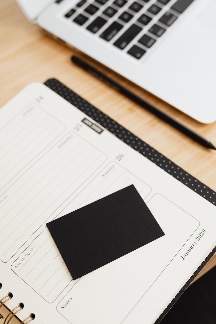 Organized office desk setup with planner, laptop, and stationery for productivity.