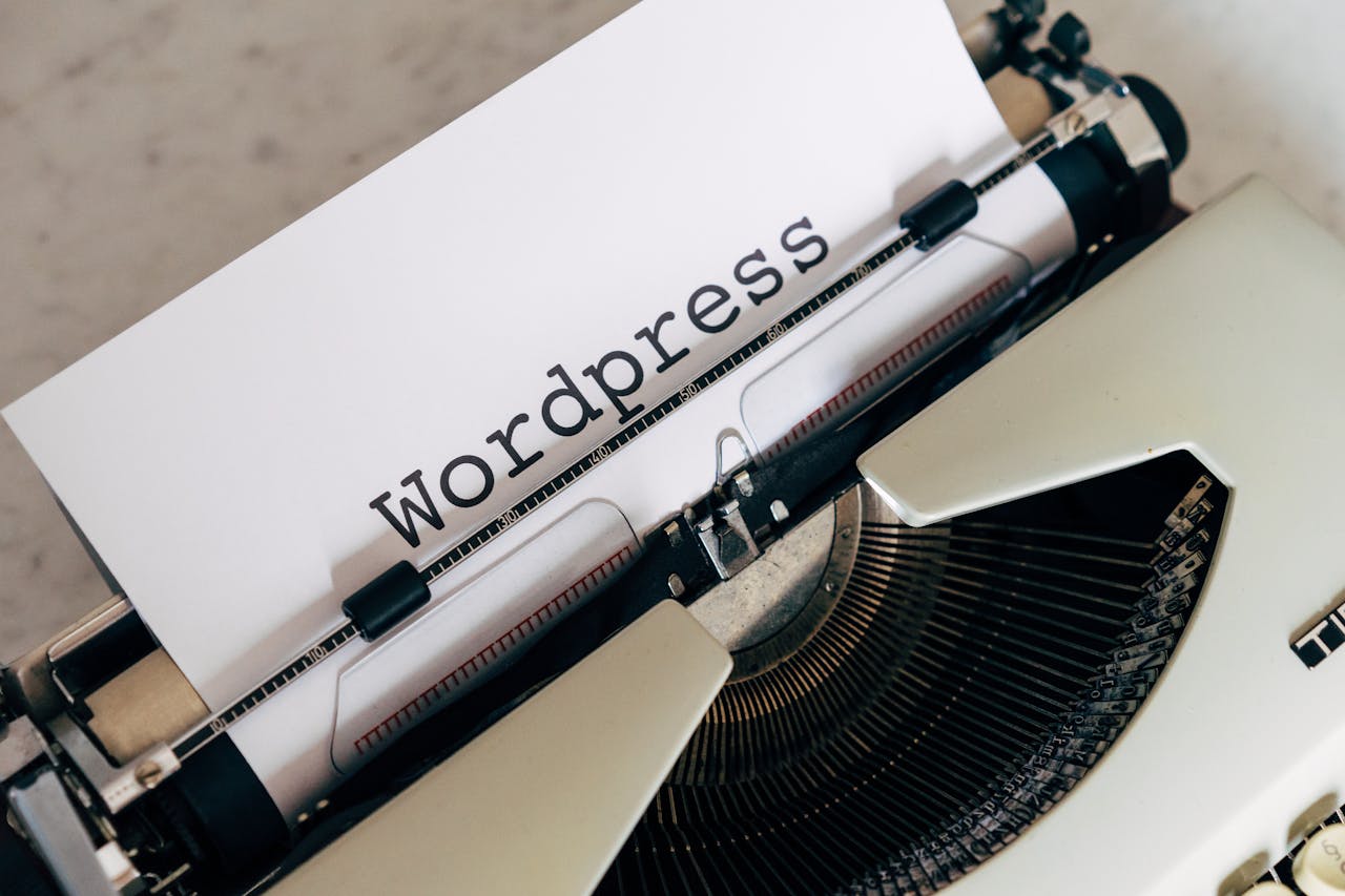 Close-up of a vintage typewriter with a paper displaying WordPress, ideal for blogging and writing concepts.